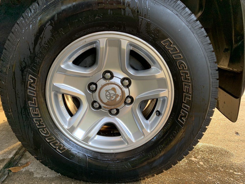 A close up of a michelin tire on a car wheel.