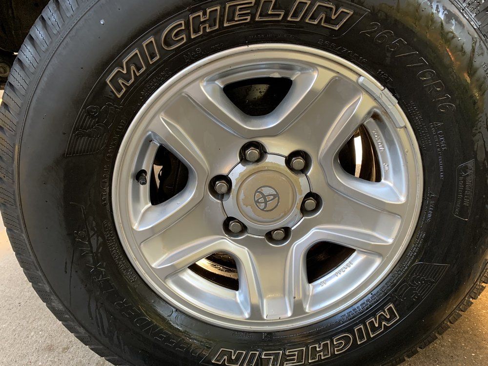 A close up of a michelin tire on a car wheel.