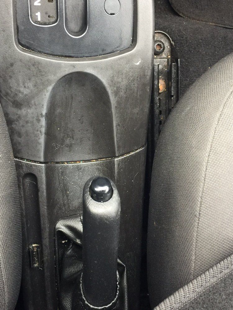 A close up of a car 's shifter and handbrake