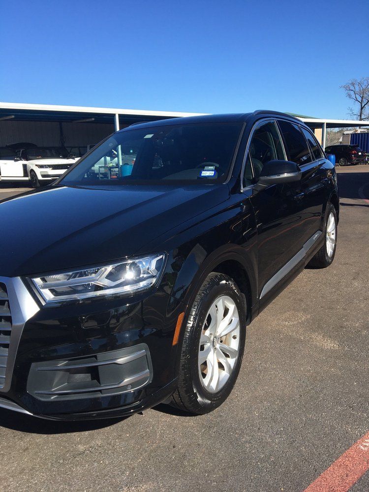 A black audi q7 is parked in a parking lot.