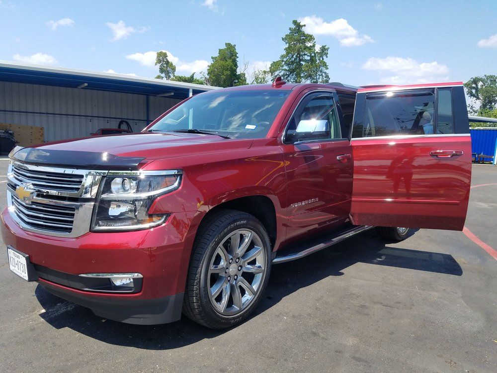 A red suv is parked in a parking lot with its doors open.
