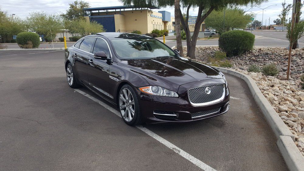 A black jaguar is parked in a parking lot.