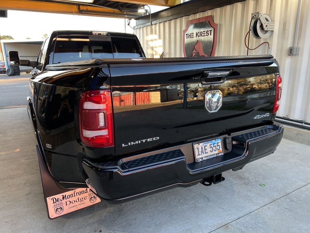 A black dodge ram truck is parked in a parking lot.