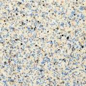 Close-up of light granite with speckled black, blue, and tan minerals.