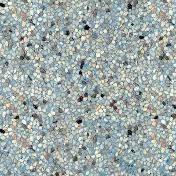 Textured surface of light blue, beige, and black mosaic tiles.