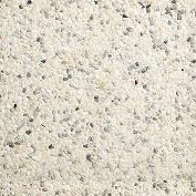 Close-up view of a light beige surface with small, scattered gray and black flecks, creating a textured appearance.