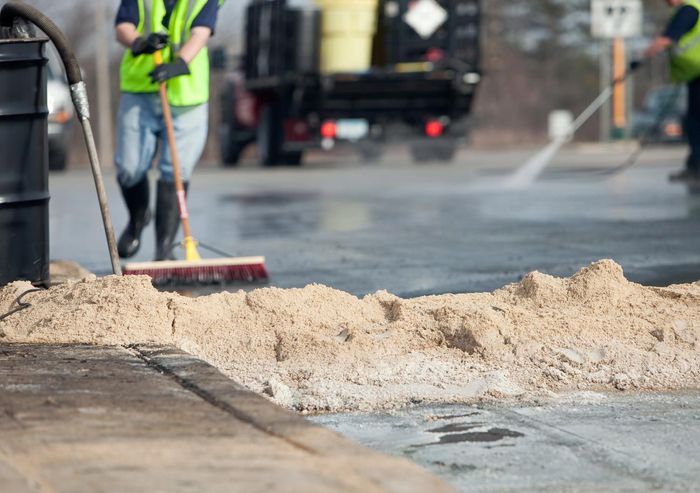 A man is sweeping the ground with a broom.