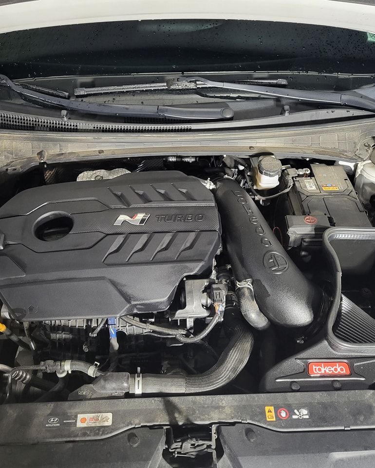 The engine of a car is shown with the hood open.