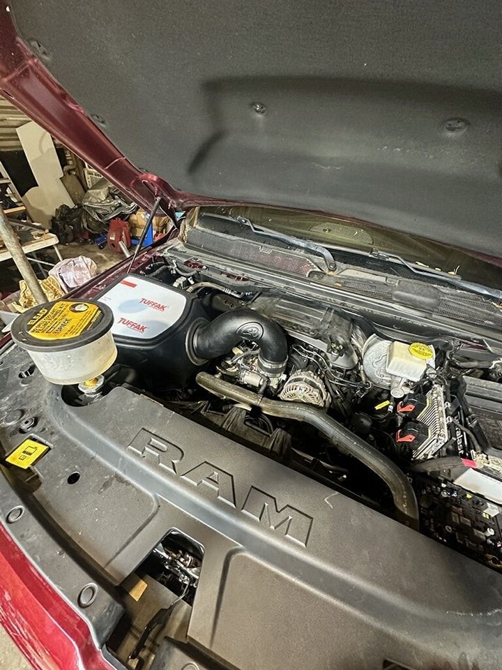 The engine of a red ram truck is shown with the hood open.