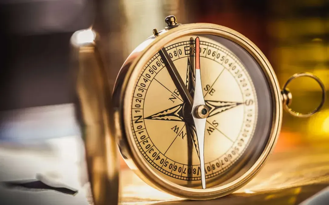 A close up of a compass on a table.