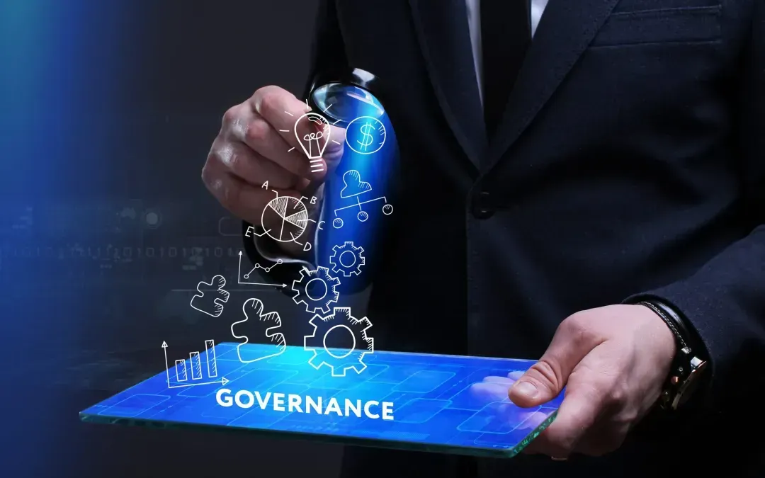 A man in a suit is holding a tablet with the word governance on it.