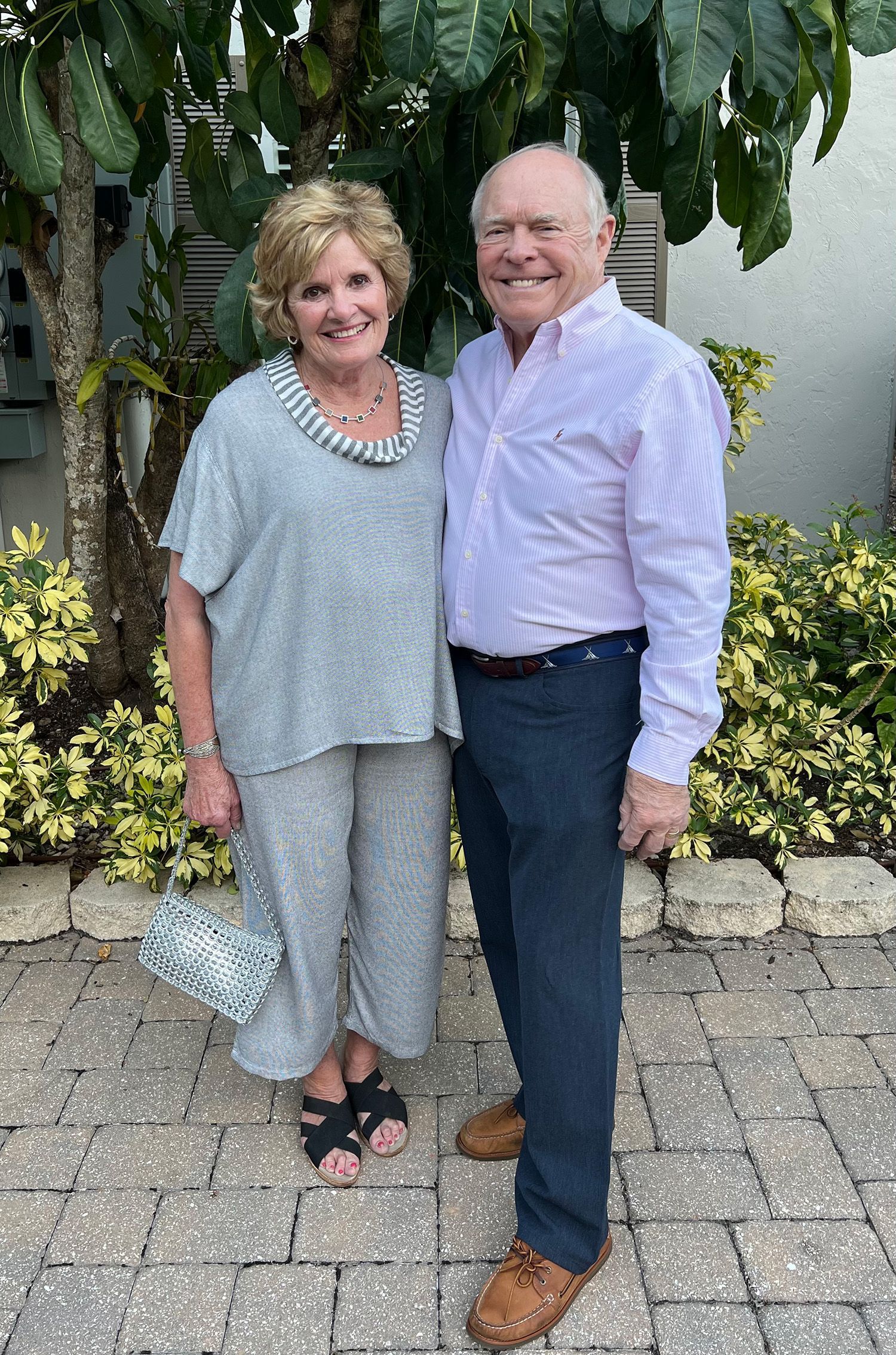 A man and a woman are standing next to each other on a brick sidewalk.