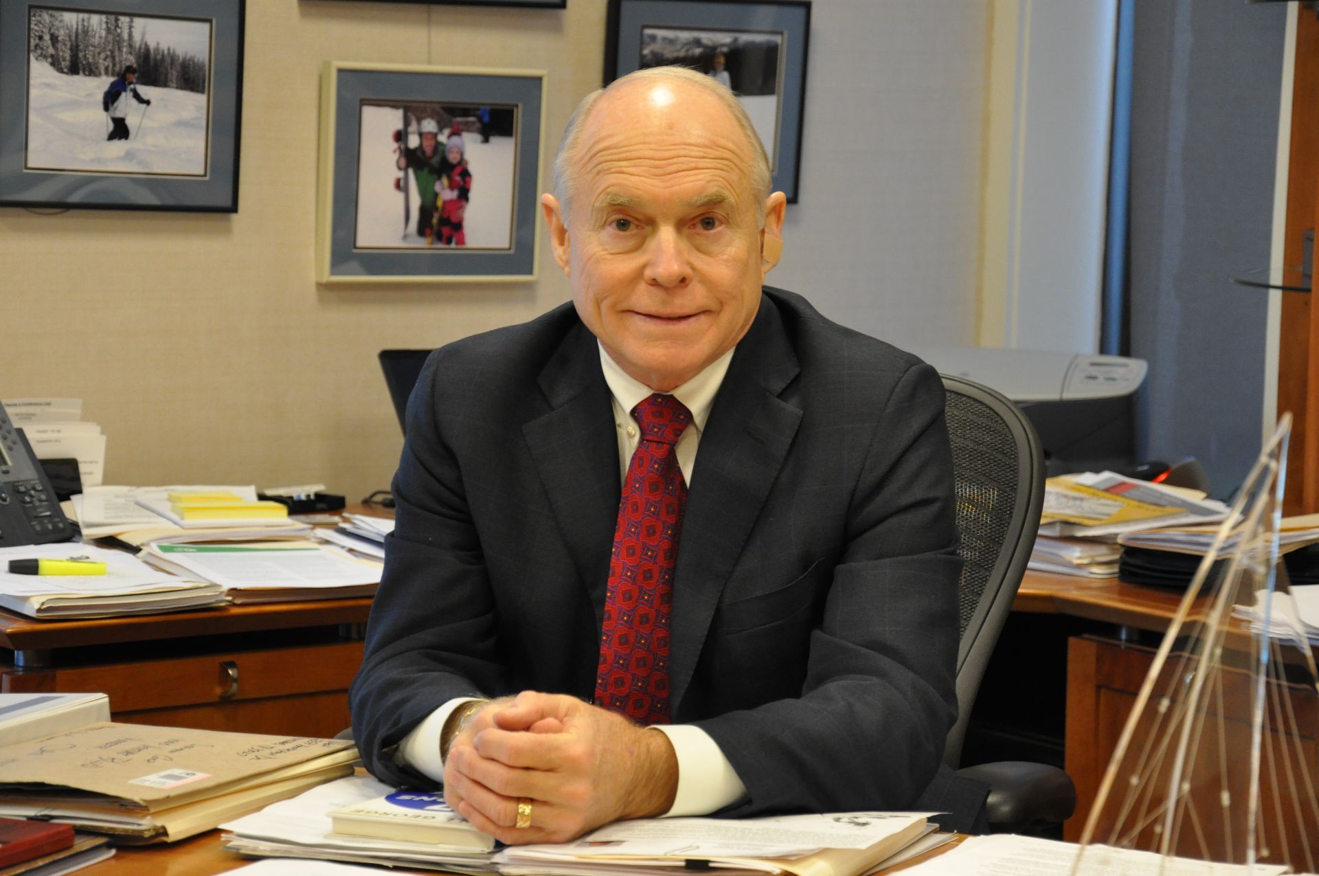 A man in a suit and tie is sitting at a desk