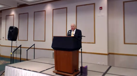 A man stands at a podium giving a speech