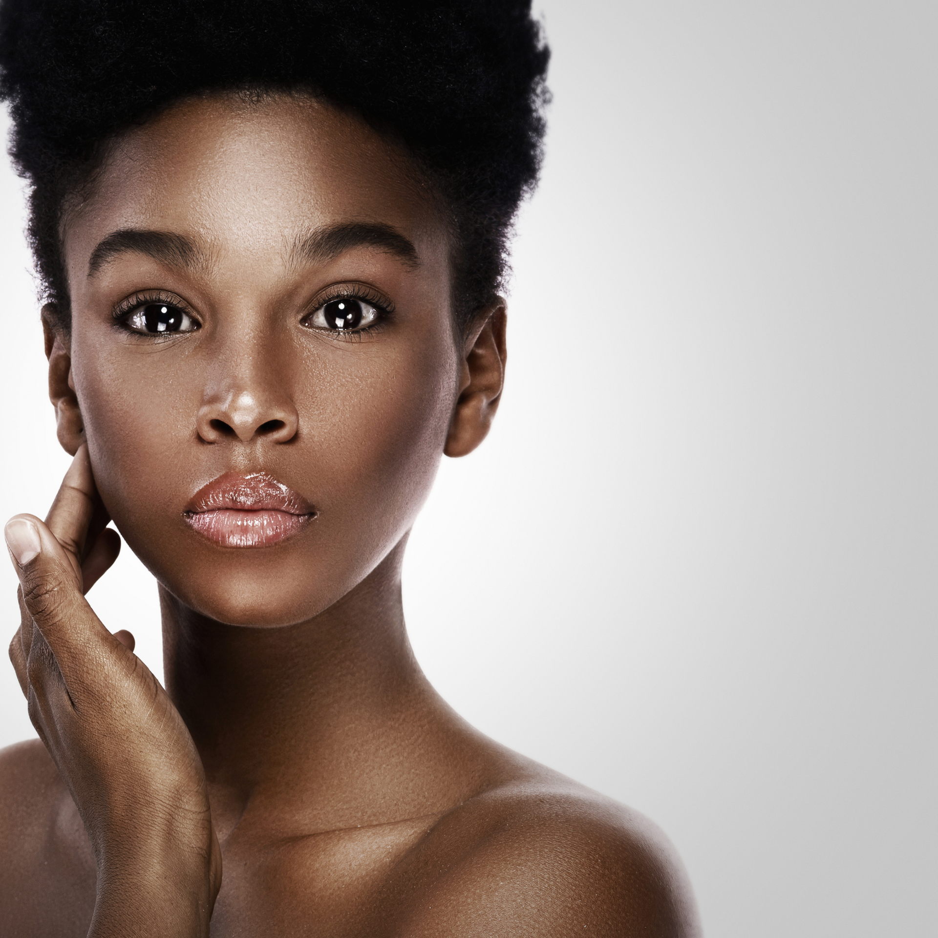 A close up of a woman 's face with her hand on her face
