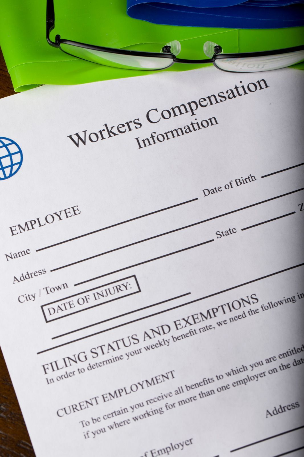 Workers Compensation information form, glasses, and green cloth.