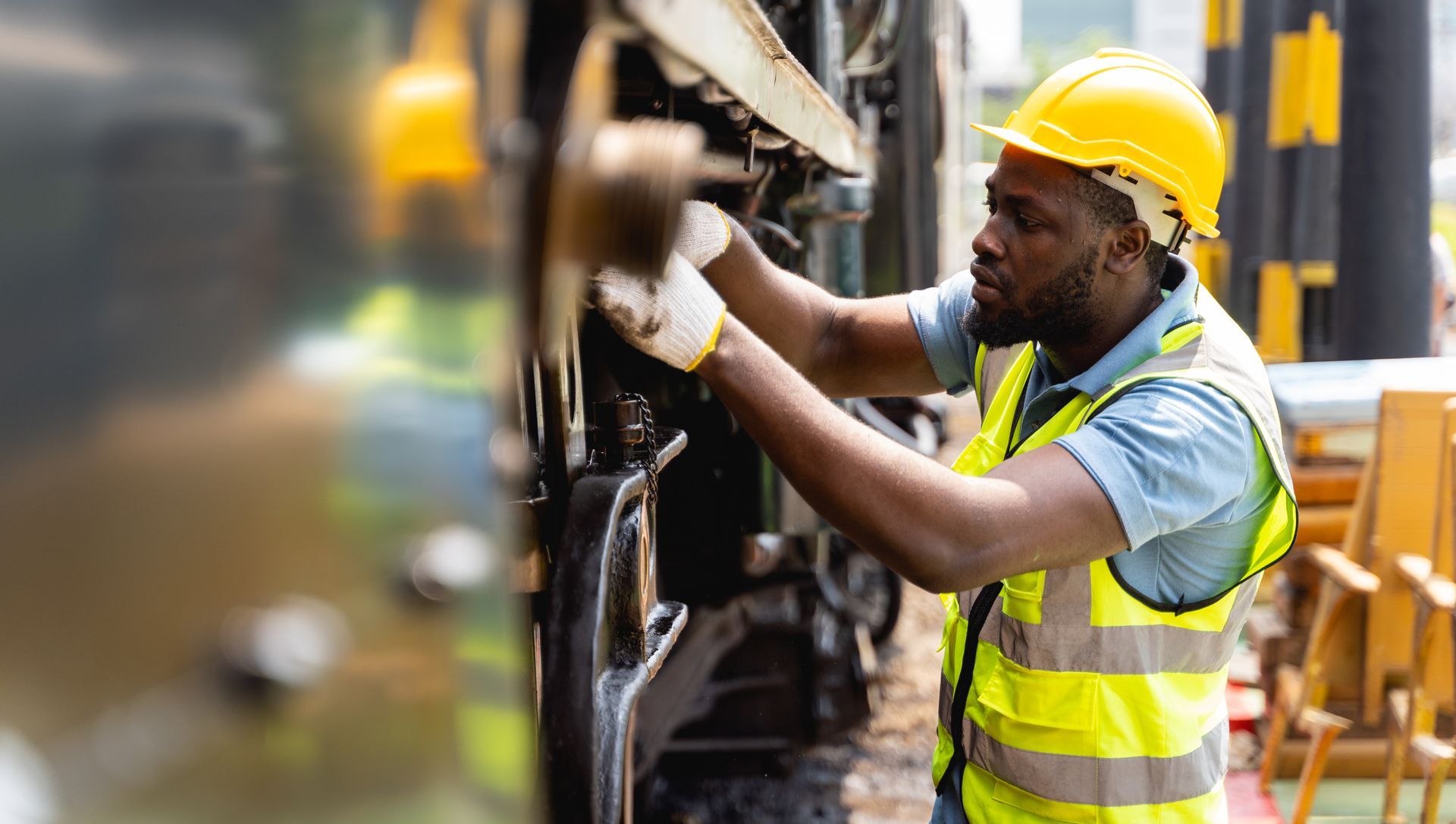 Professional engineers in safety attire inspecting and maintaining large machines with focus and intent.