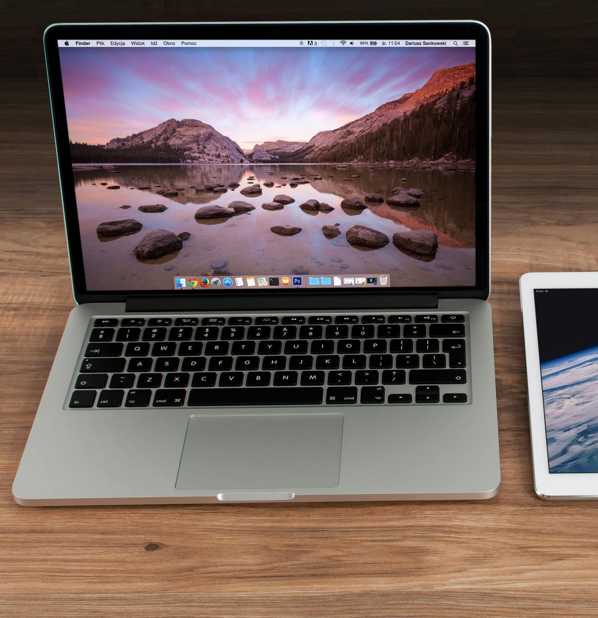 Un laptop e un tablet sono su un tavolo di legno