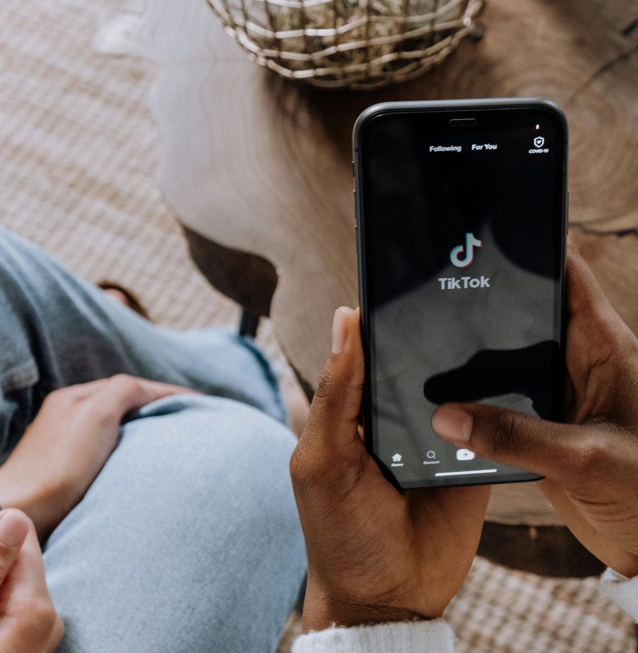 Una persona tiene in mano un cellulare con TikTok sullo schermo