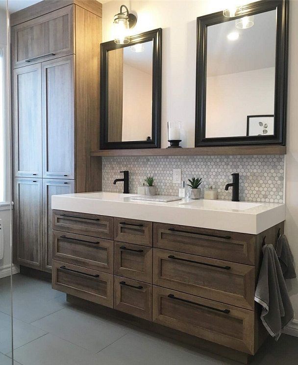 Une salle de bain avec deux lavabos et deux miroirs.