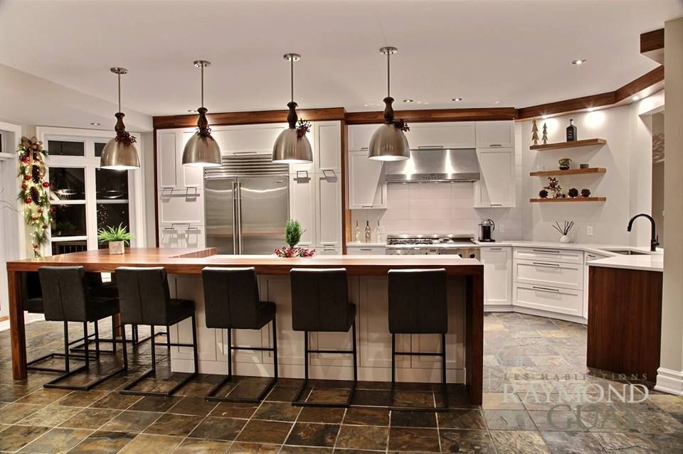 Une cuisine avec des armoires blanches et des appareils électroménagers en acier inoxydable