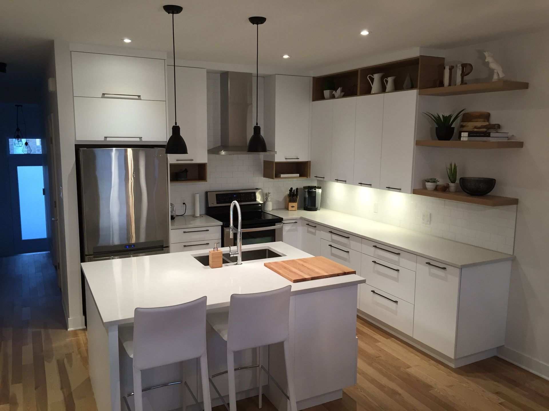 Une cuisine avec des armoires blanches et des appareils électroménagers en acier inoxydable