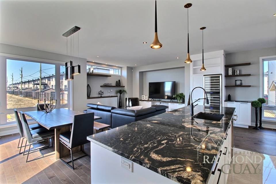 Une cuisine avec un comptoir en granit noir et une table à manger.