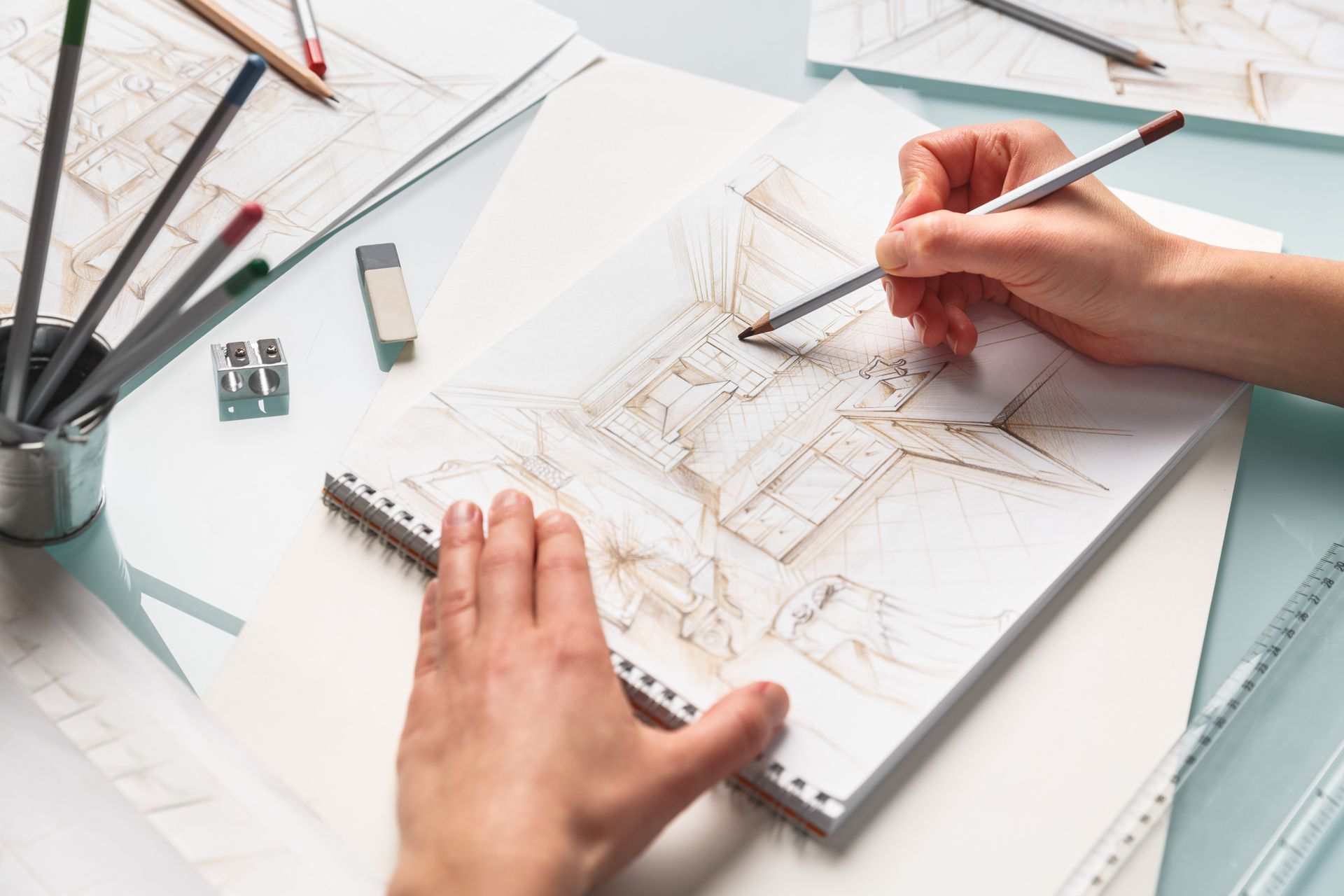 Une personne dessine sur une feuille de papier avec un crayon.