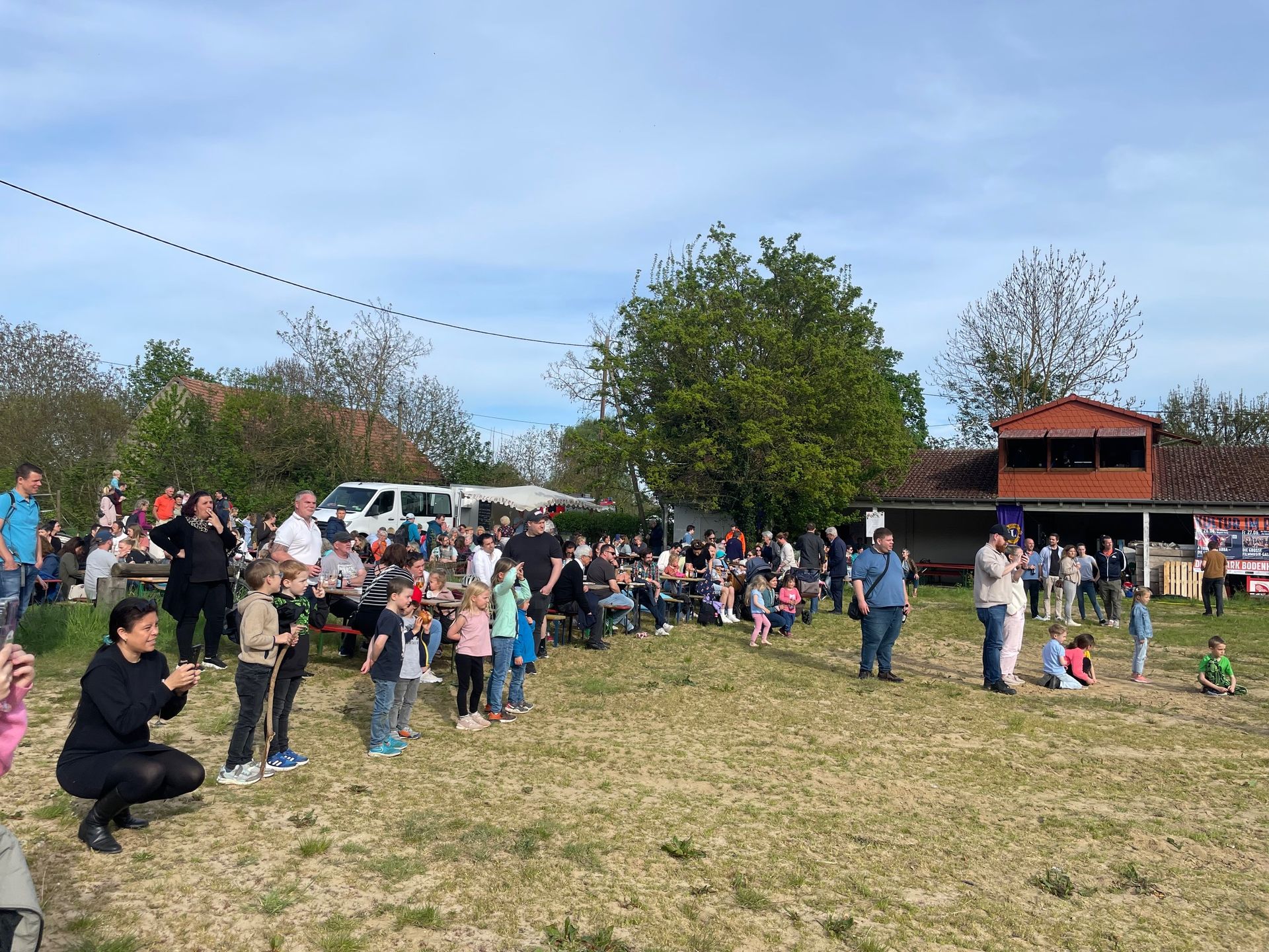 Eine Gruppe von Menschen steht auf einer Wiese.