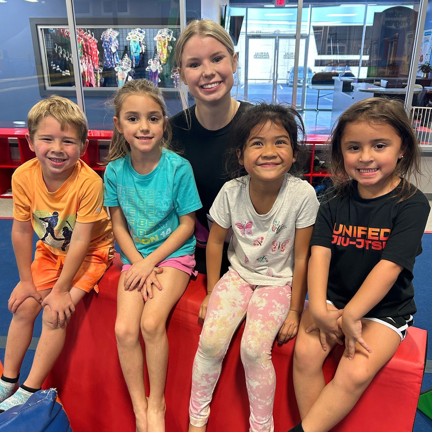 A group of children are posing for a picture in front of a bouncy house.