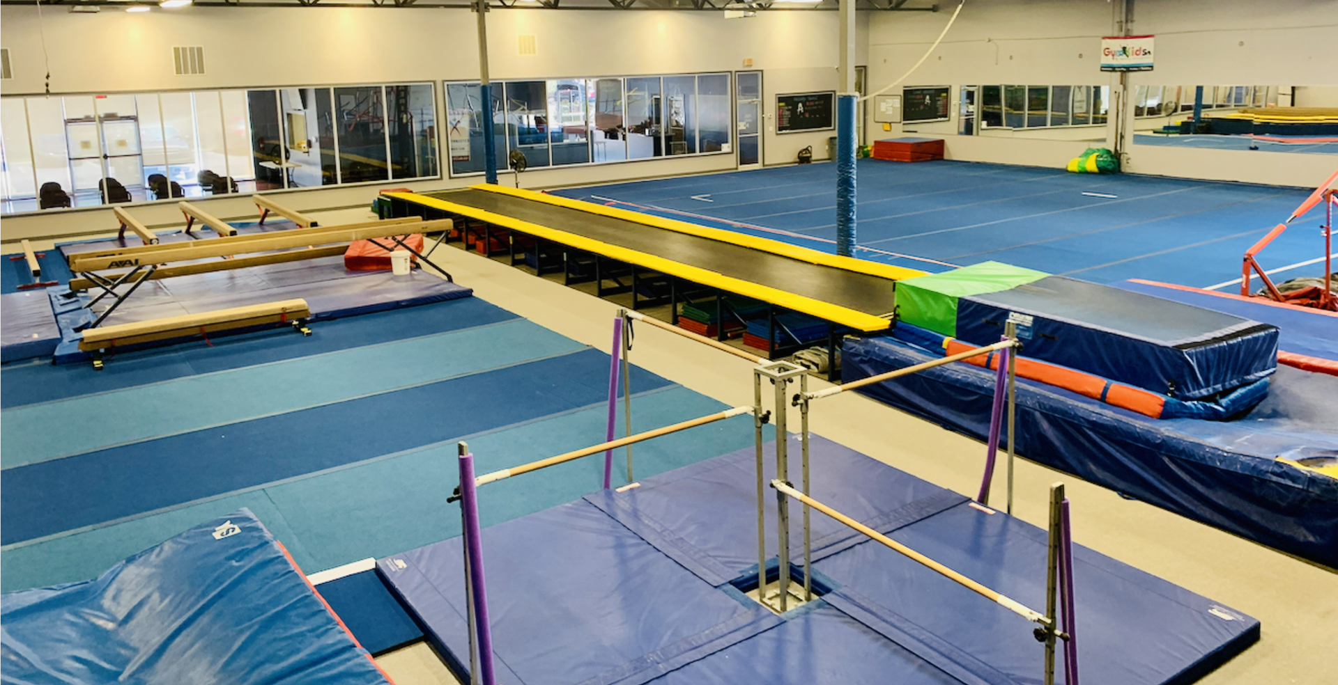 A gym with a bunch of bars and a basketball hoop.