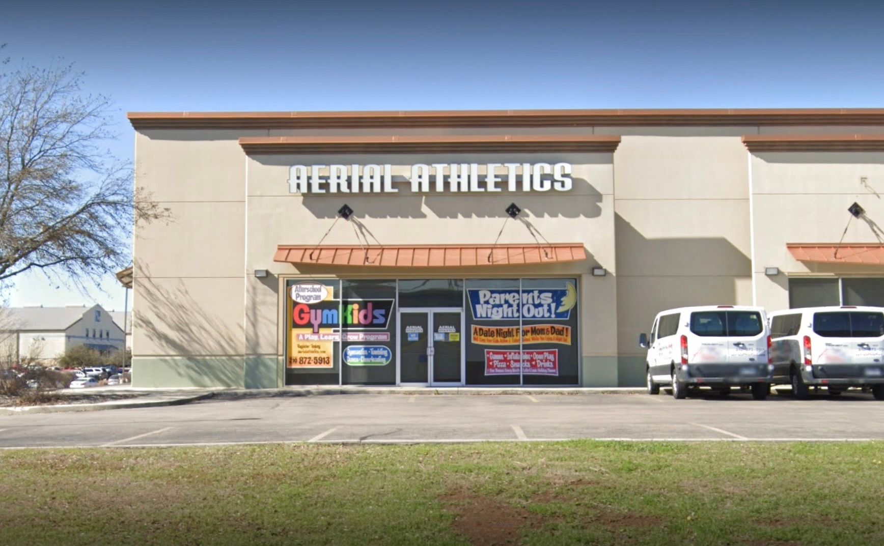 A aerial athletics store with cars parked in front of it.