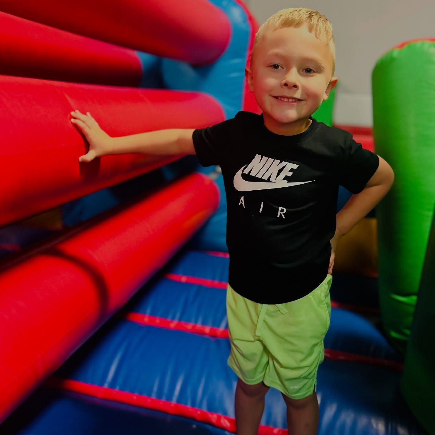 Two young boys are sitting on chairs eating cotton candy
