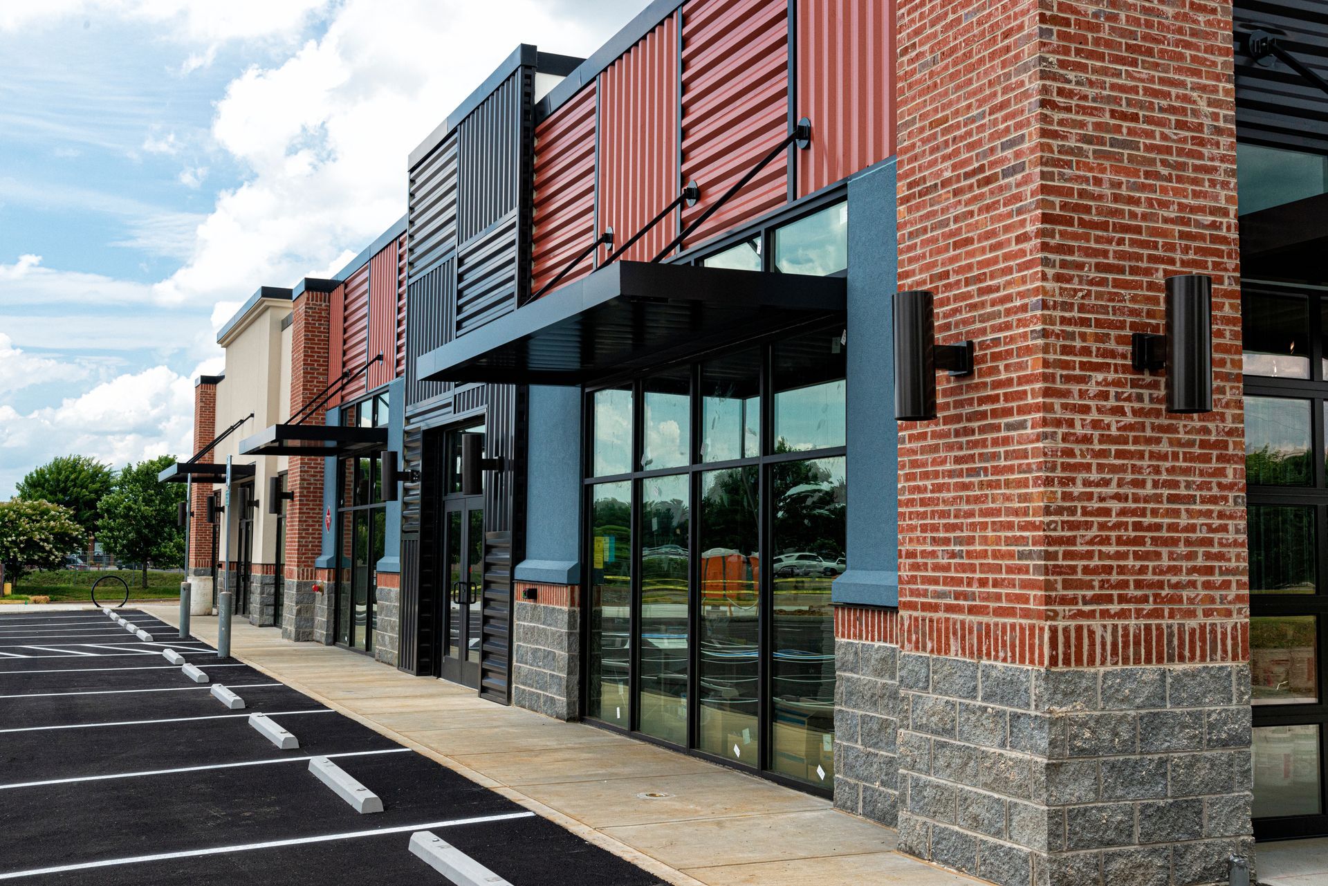 A row of brick buildings with a parking lot in front of them.