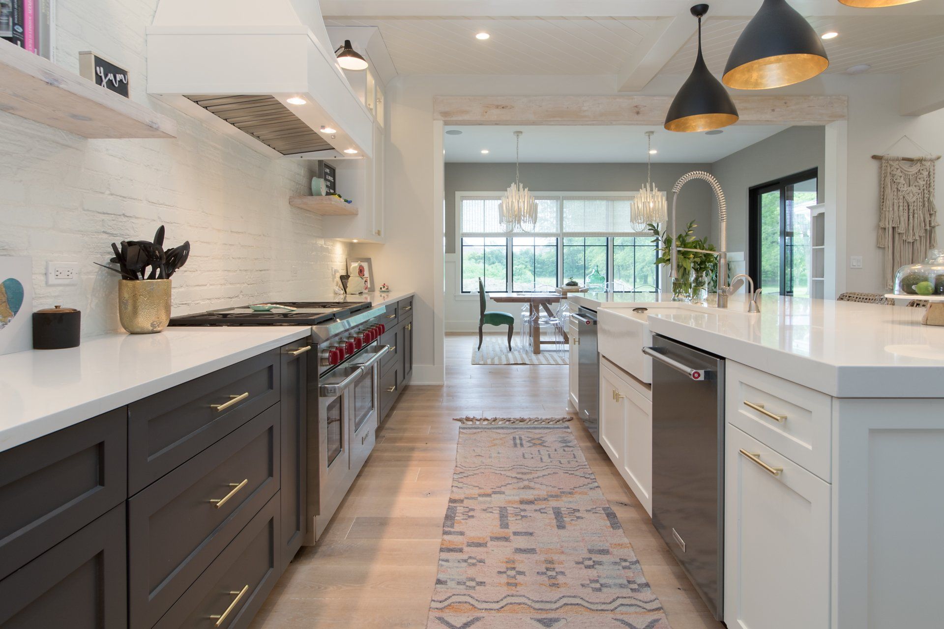 A kitchen with black cabinets , white counter tops , and stainless steel appliances.