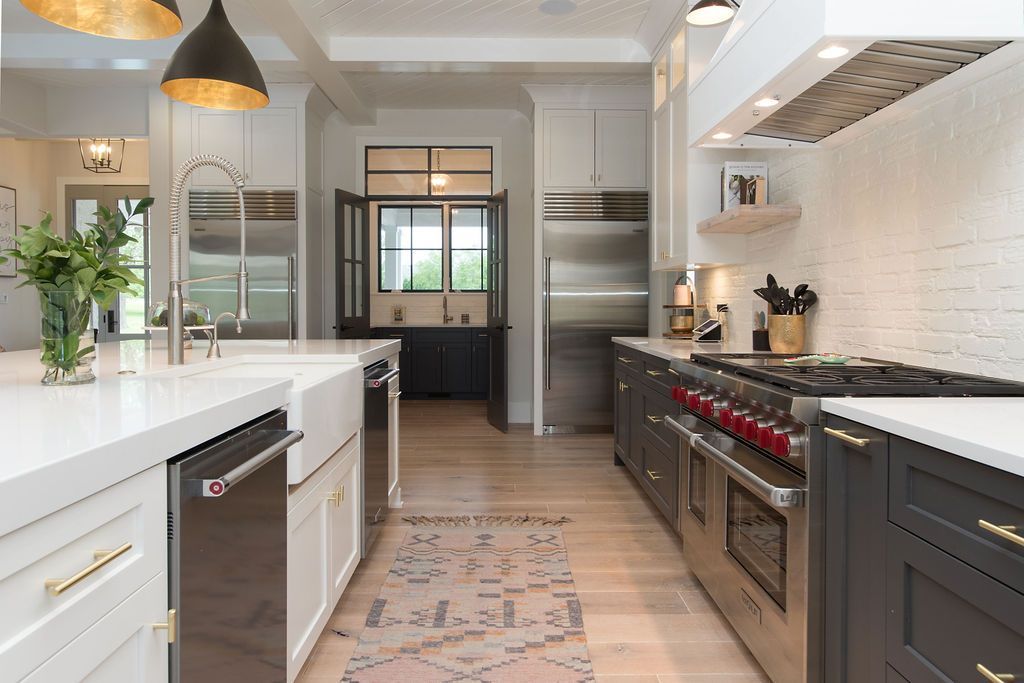 Modern kitchen with white countertops, stainless steel appliances, and dark cabinetry.