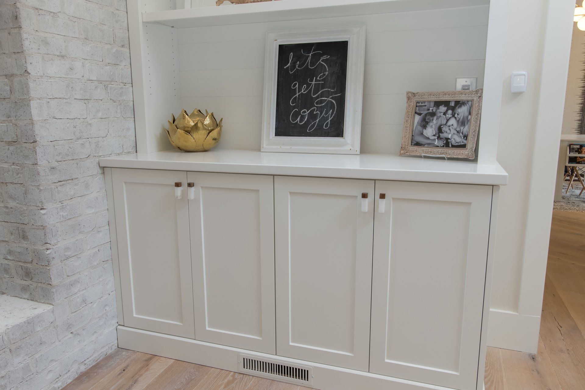 A white cabinet with a chalkboard on top of it.