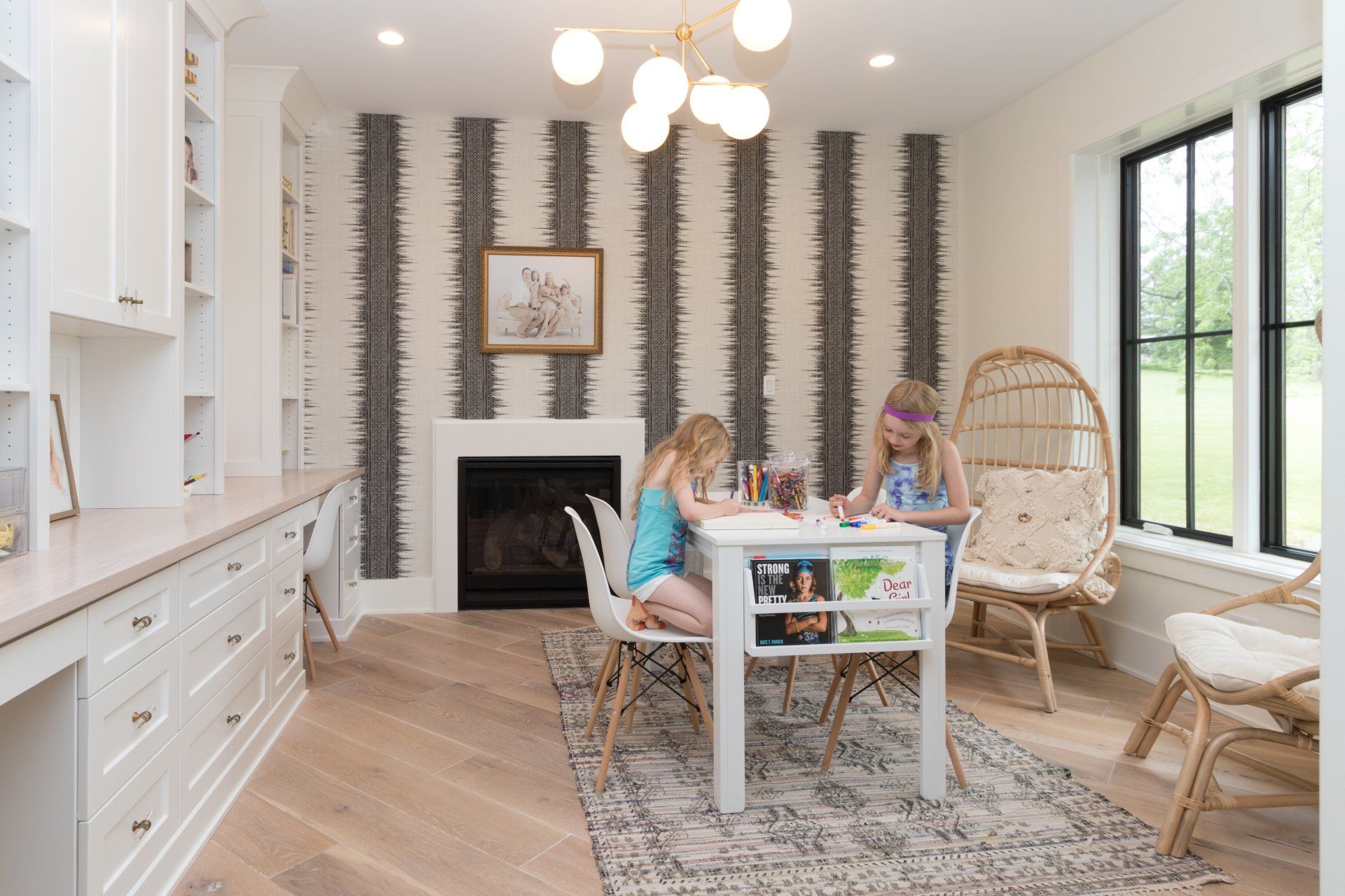 Two girls are sitting at a table in a living room.