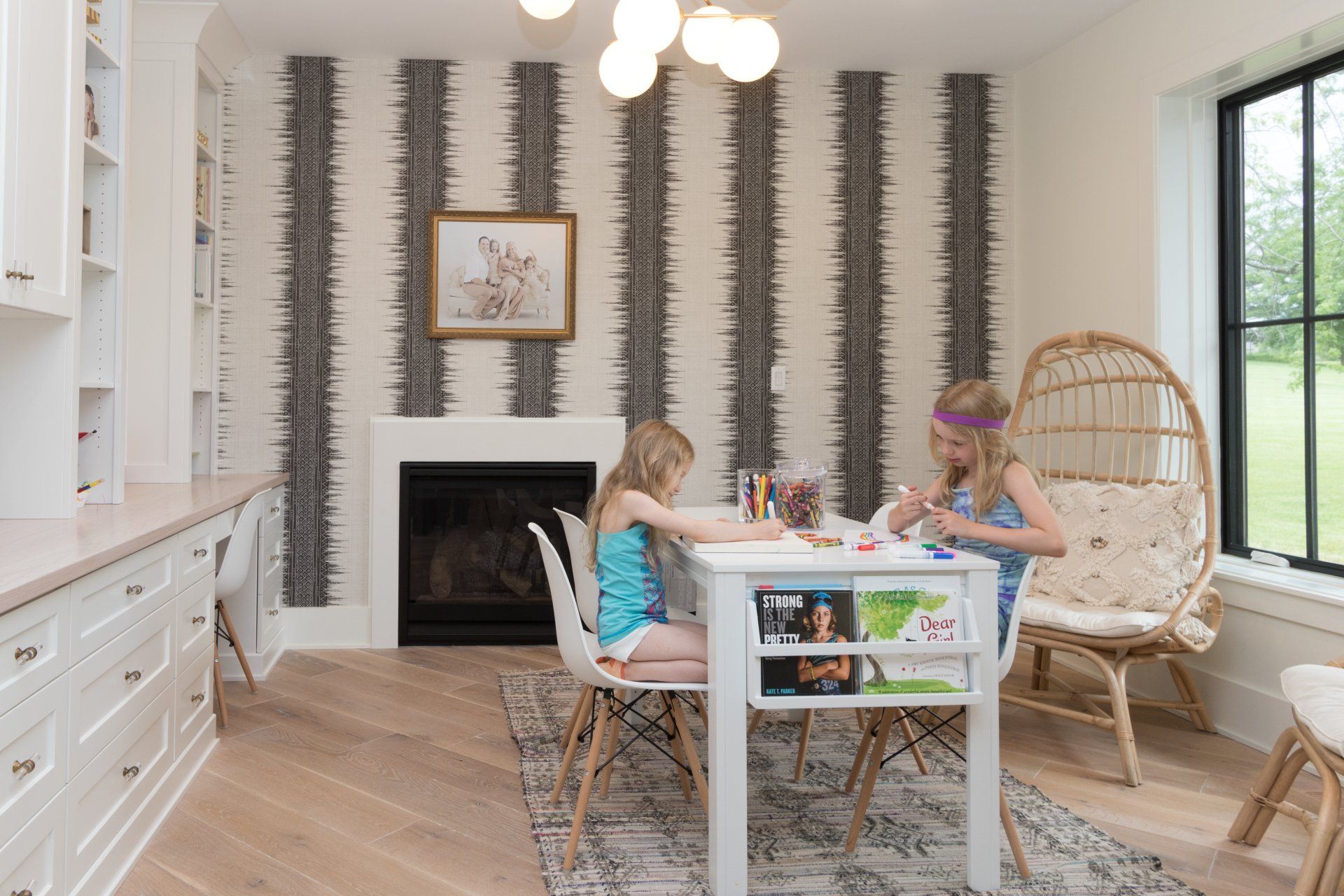 Two young girls are sitting at a table in a living room.