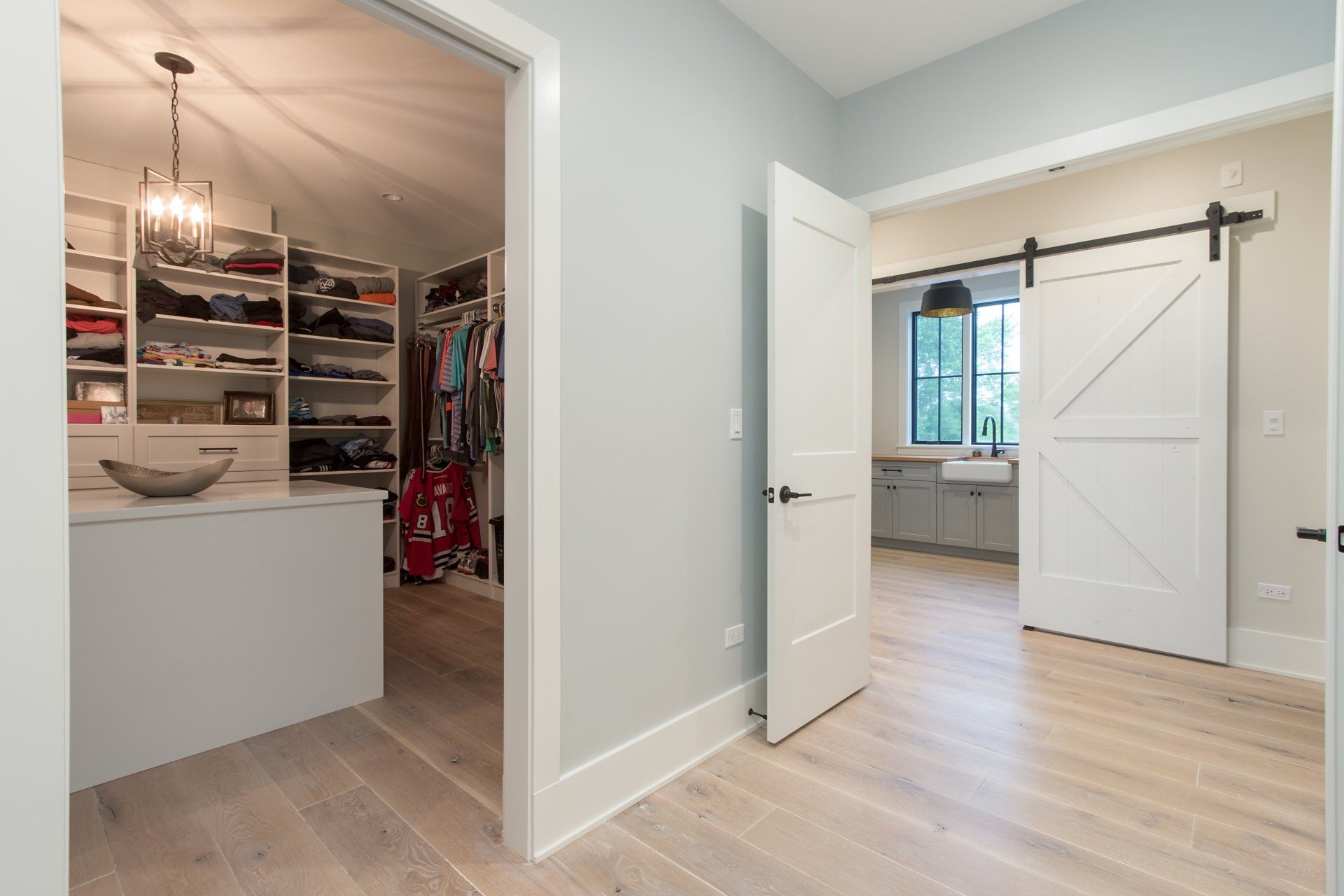 A walk in closet with sliding barn doors in a house.