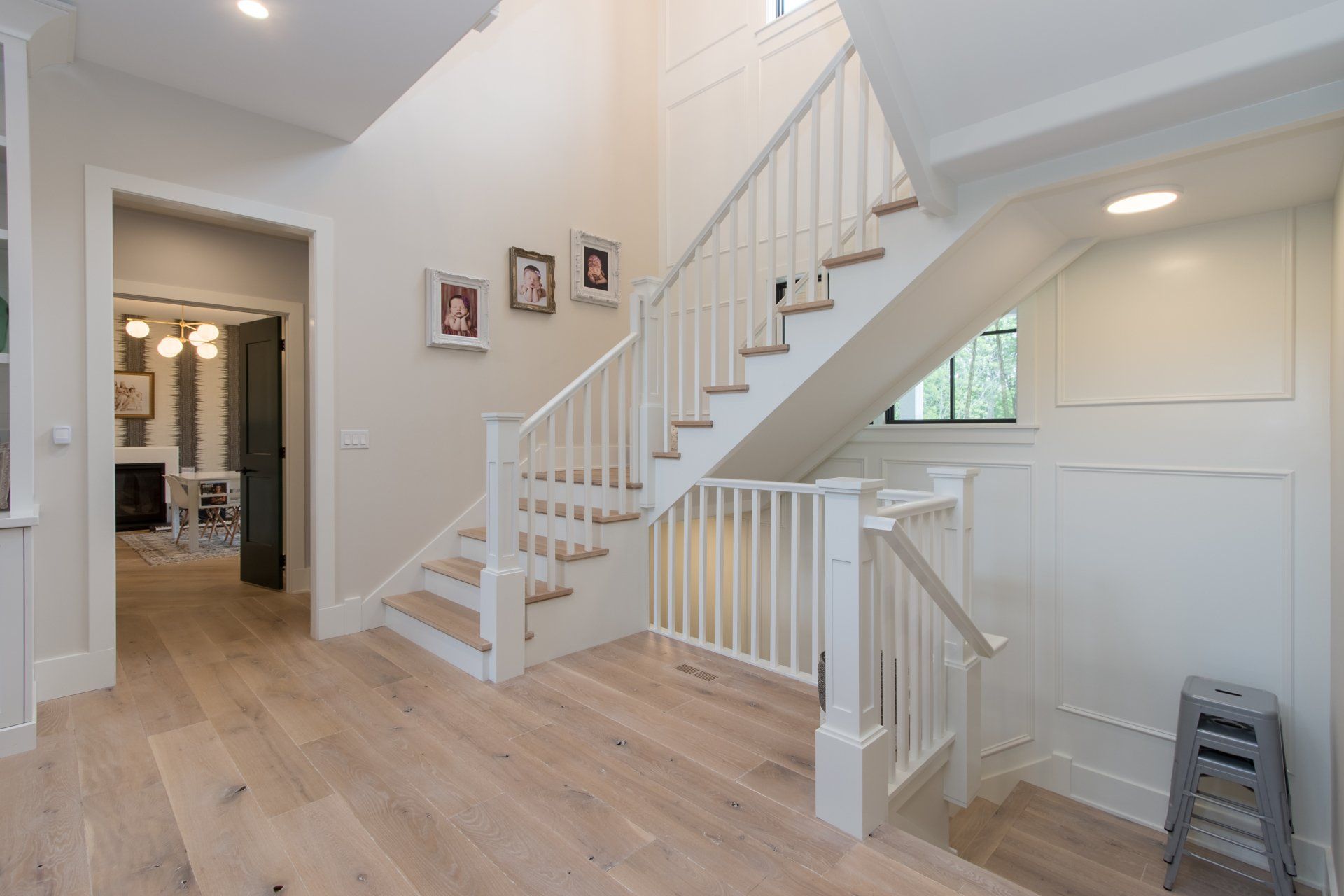 A white staircase with wooden steps and a white railing in a house.