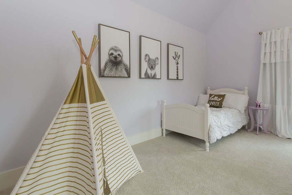 Child's room with a teepee, white bed, animal art, and sheer curtains. Soft purple walls and carpet.