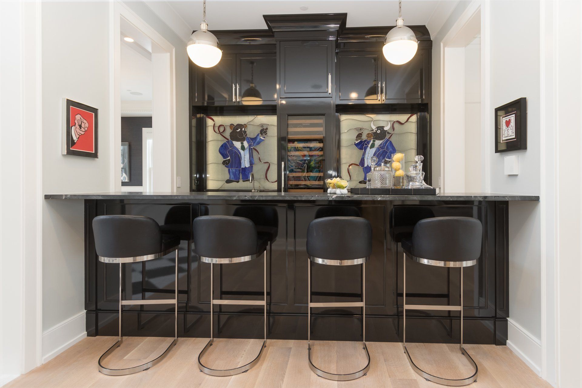 A kitchen with a bar and stools and a refrigerator.