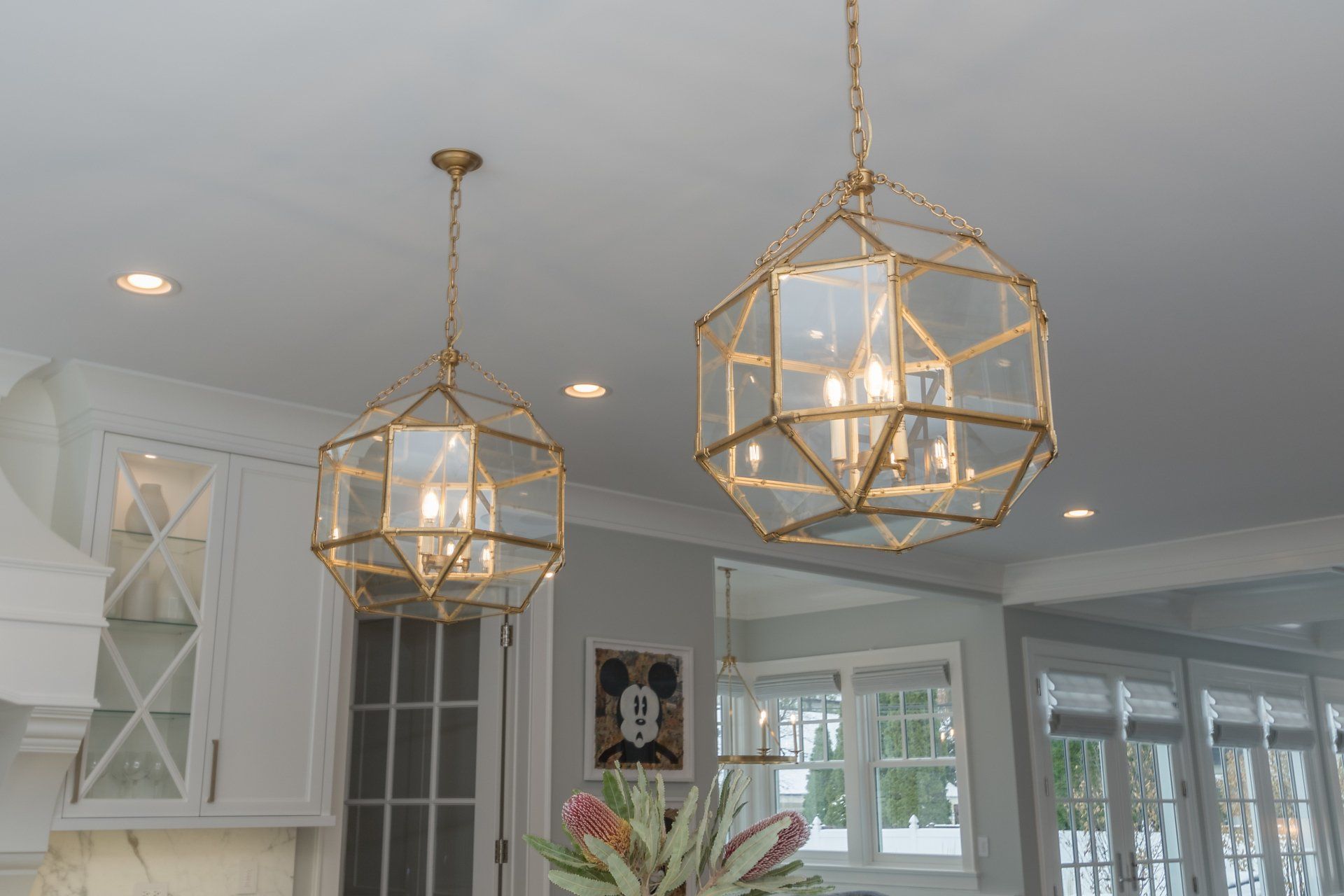 Two pendant lights are hanging from the ceiling in a kitchen.