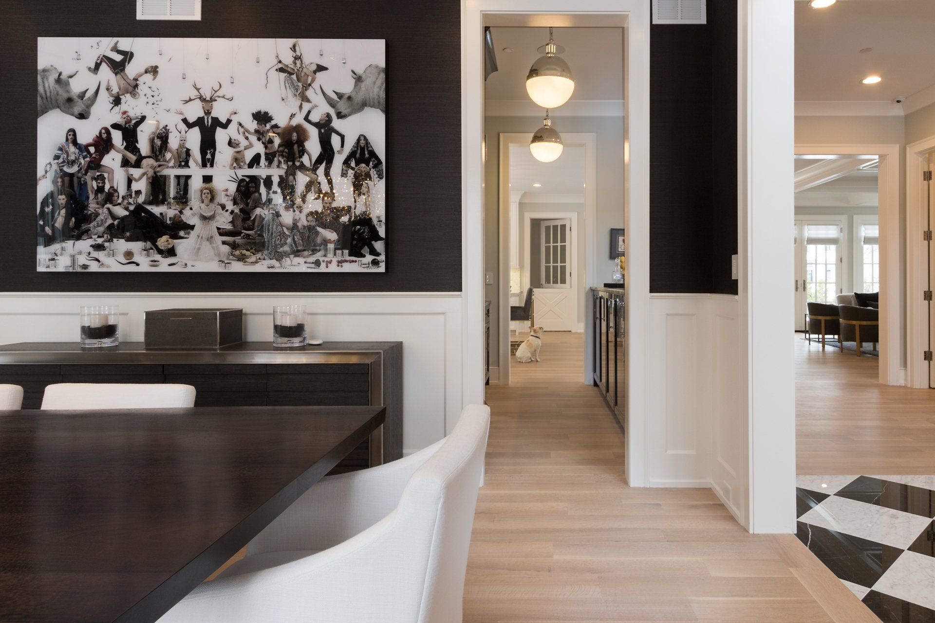 A dining room with a table and chairs and a painting on the wall.