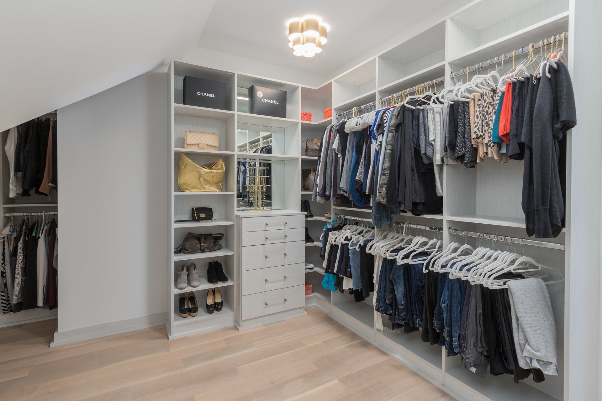 A walk in closet filled with lots of clothes and shoes.