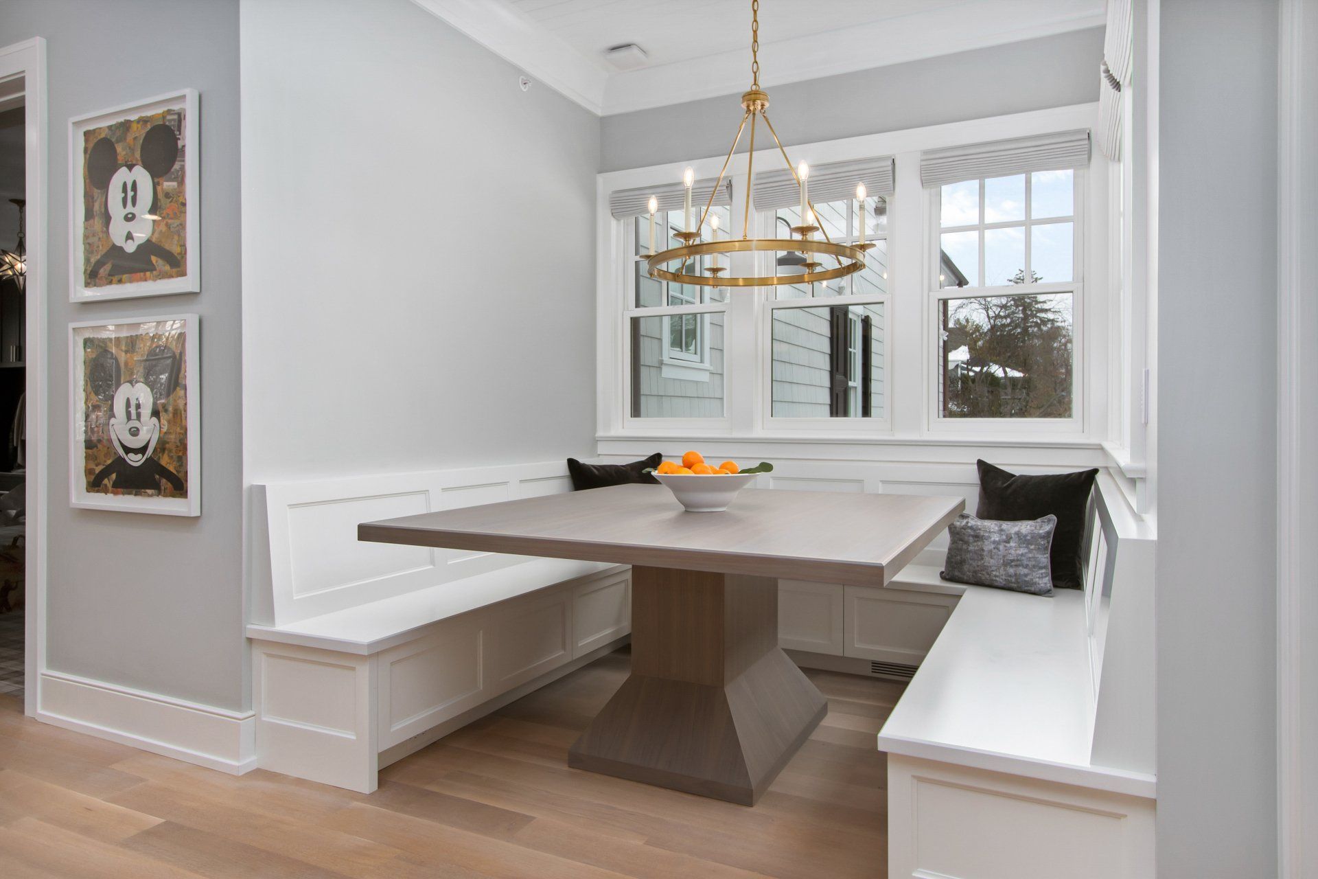 A dining room with a table and benches and a chandelier.