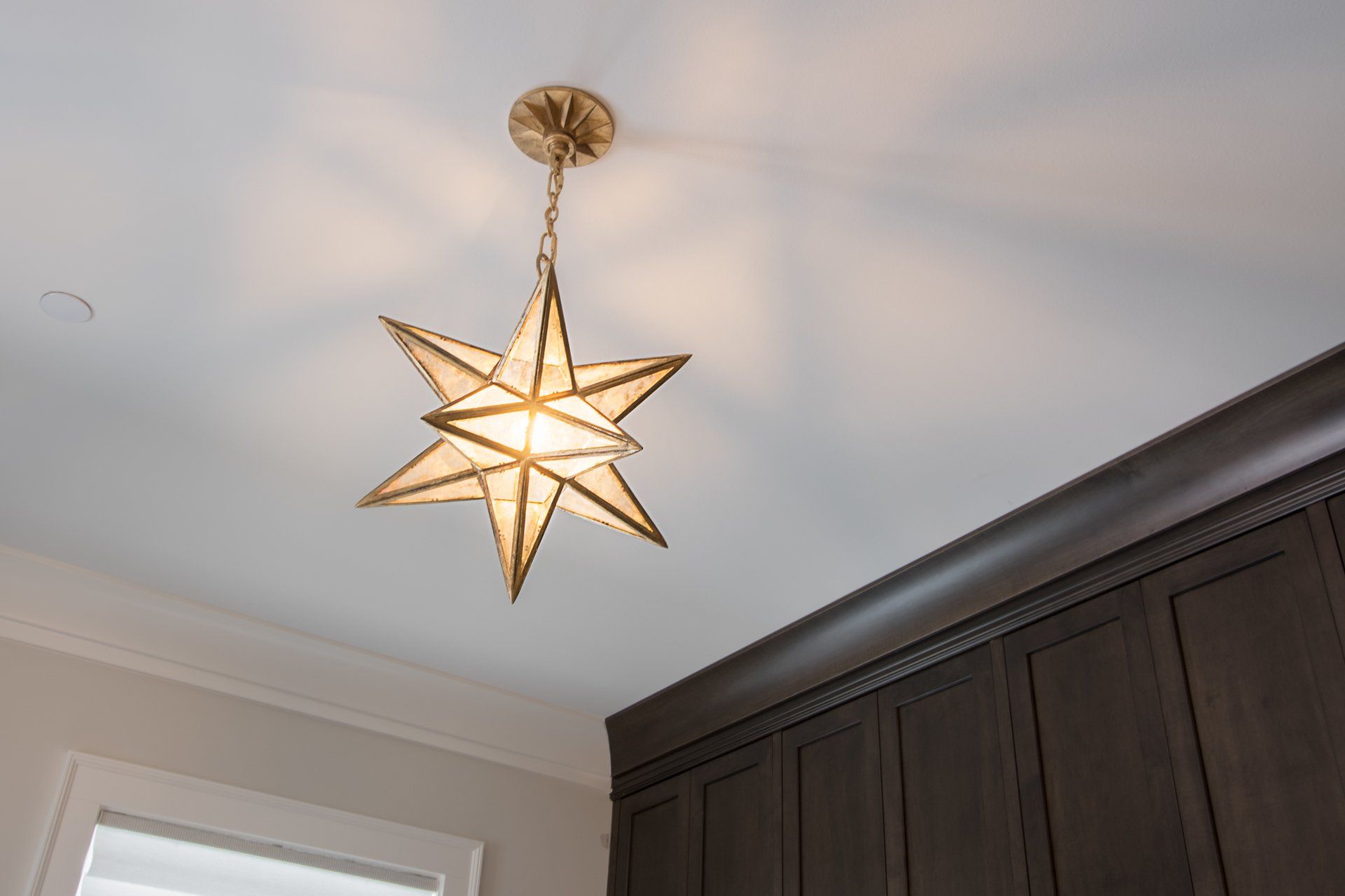 A star shaped light fixture is hanging from the ceiling
