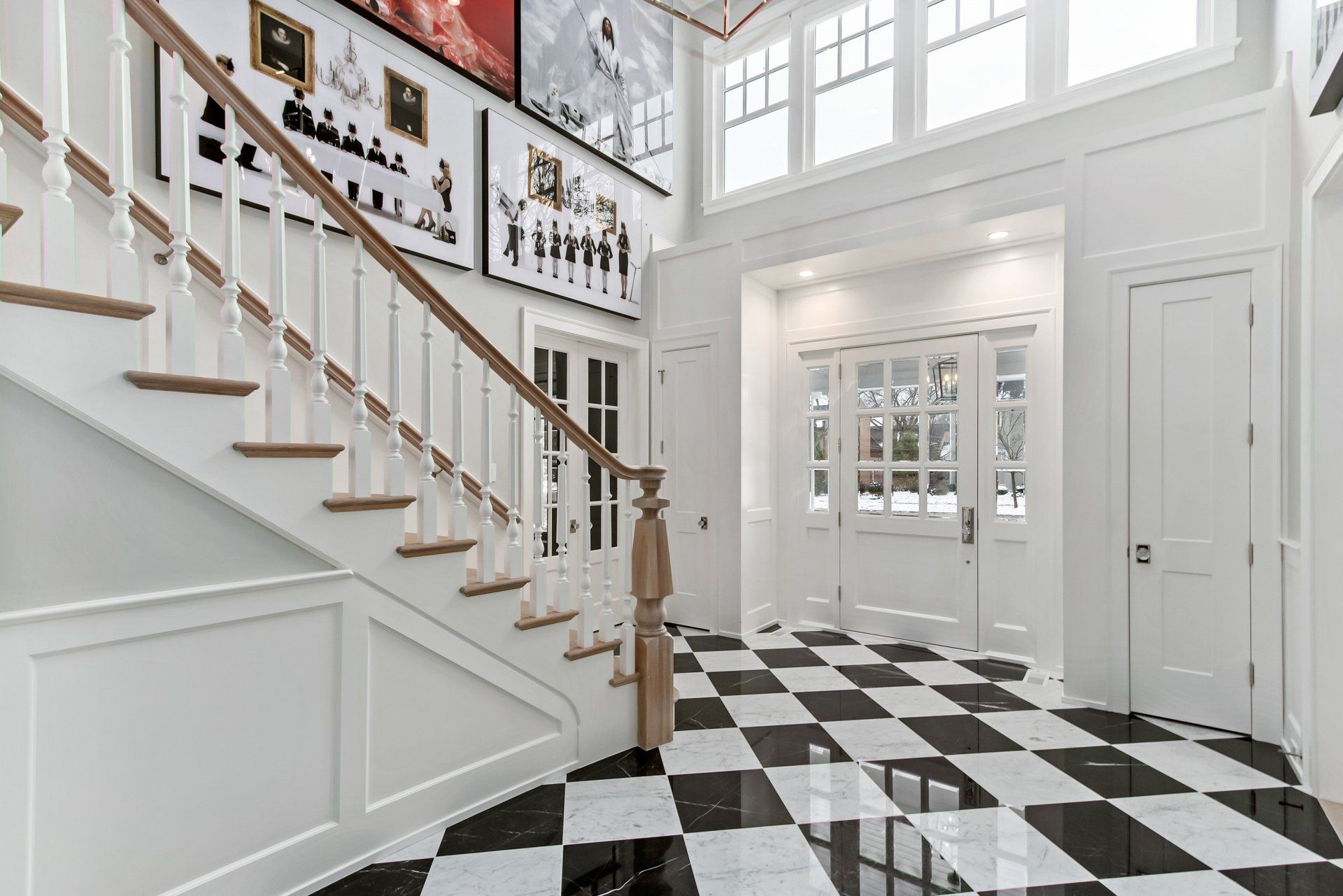 There is a staircase in the middle of the hallway with a checkered floor.