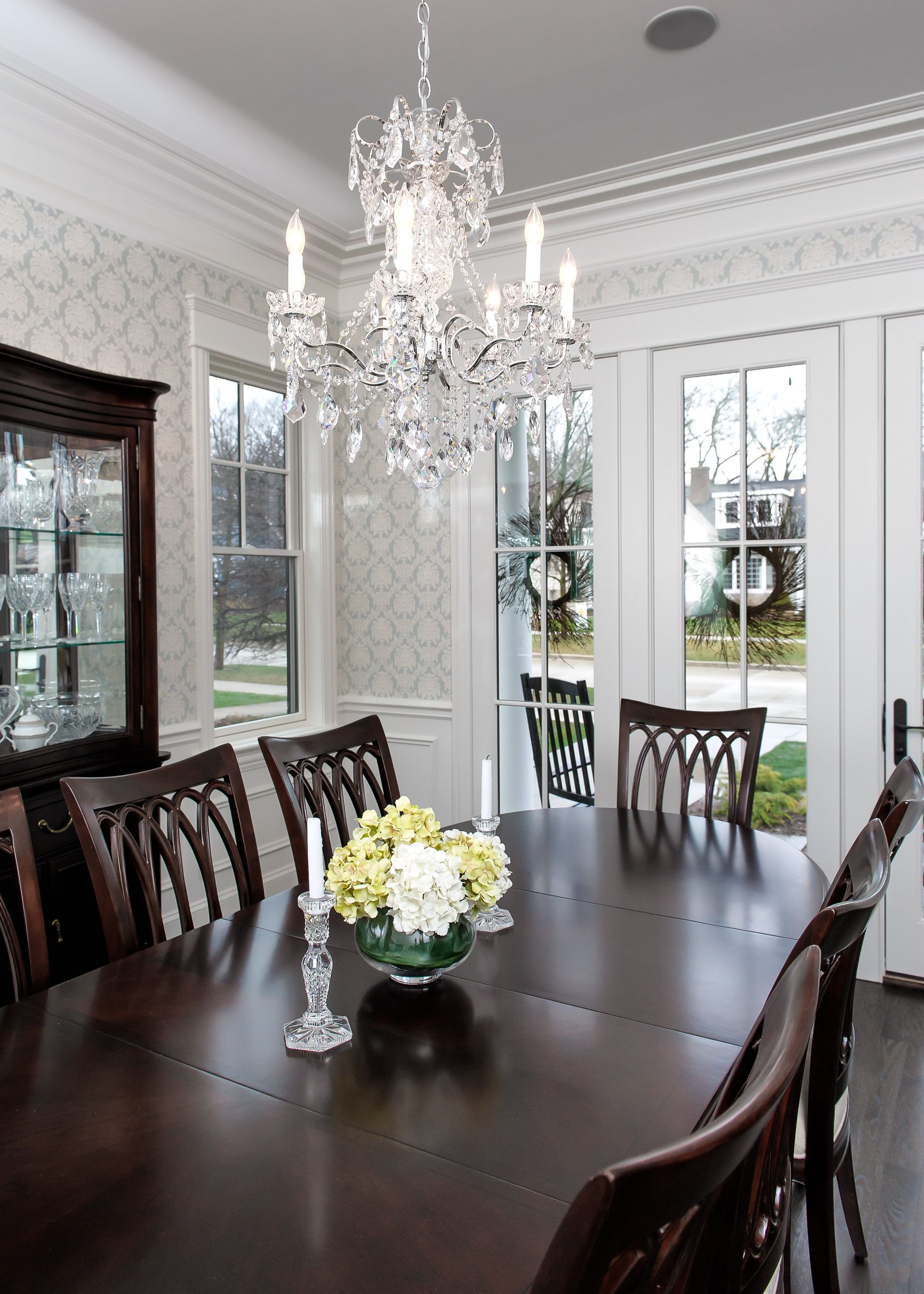 A dining room with a table and chairs and a chandelier